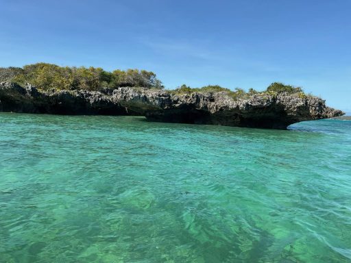 Rochers émergeant d'une mer turquoise sous un ciel clair.